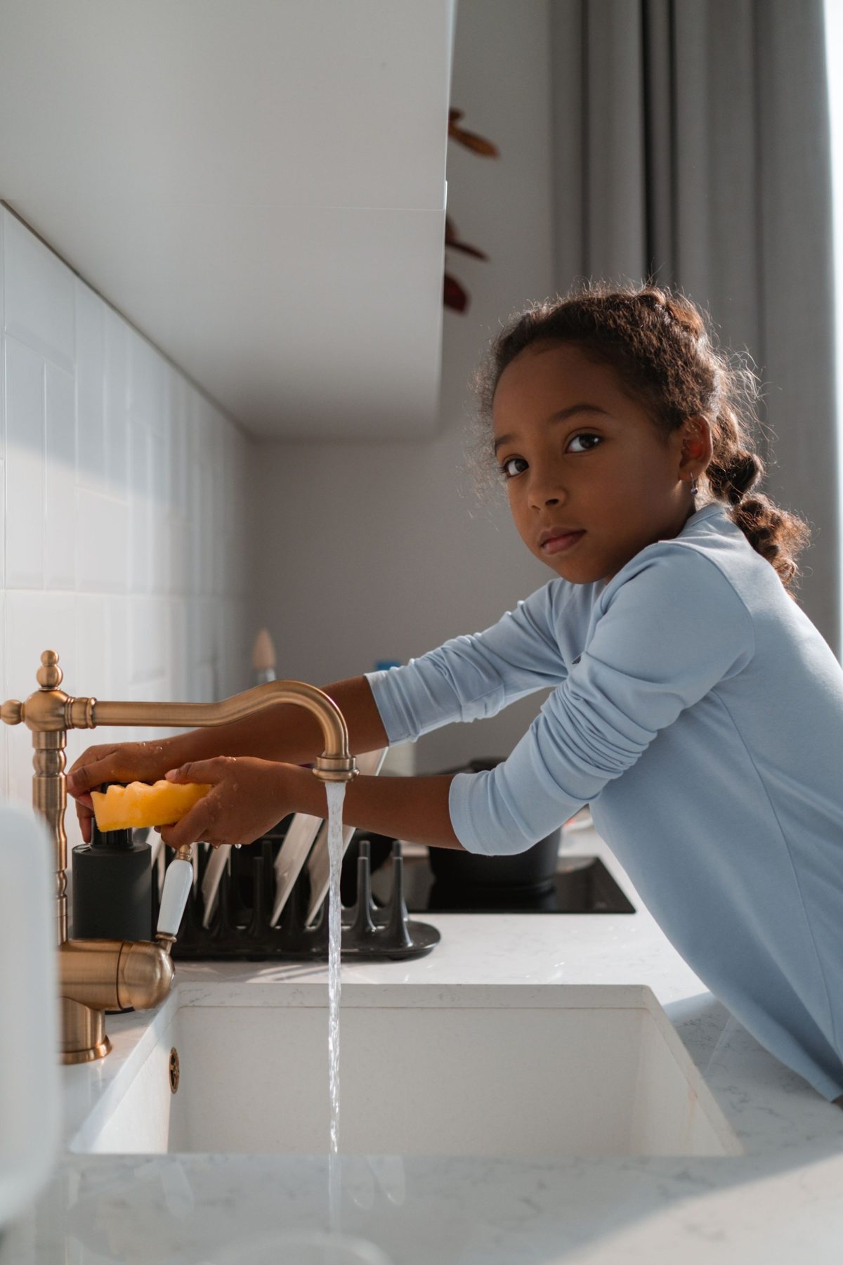 Girl at the kitchen tap